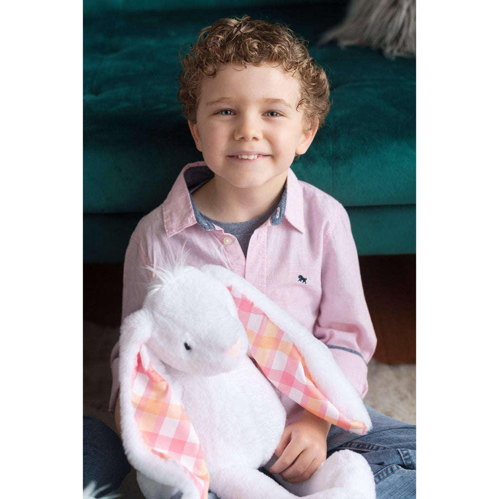 young boy holding a large plush rabbit