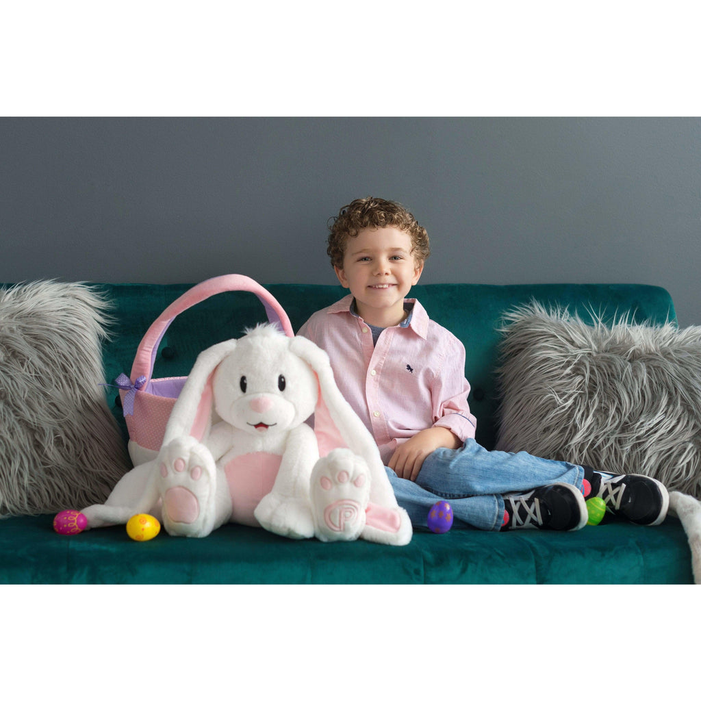 young boy sitting on couch with plush bunny and plush basket