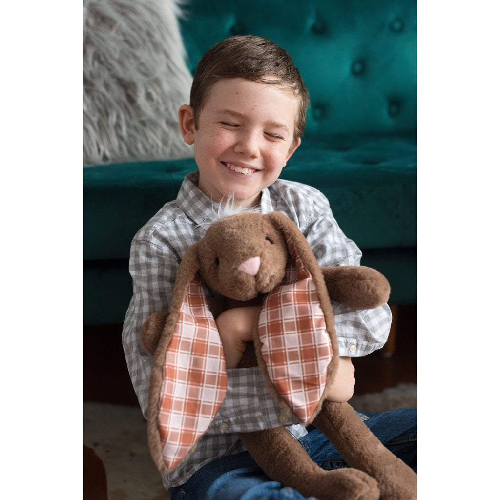 young happy boy holding a brown stuffed bunny