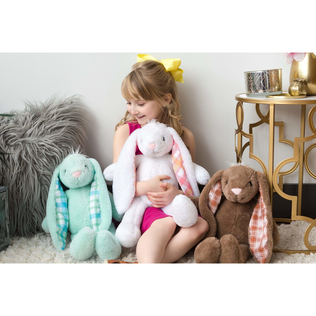 small child sitting with three large stuffed animals